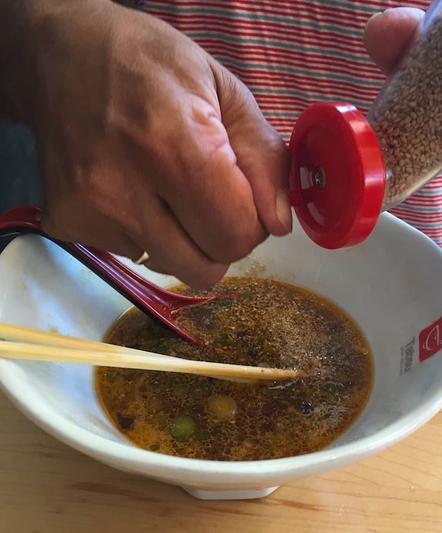 sesame seed in grinder being added to soup