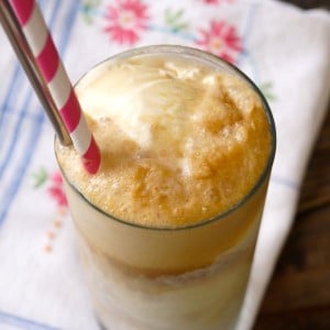 The Best Root Beer Float in a tall glass with a pink and white striped straw
