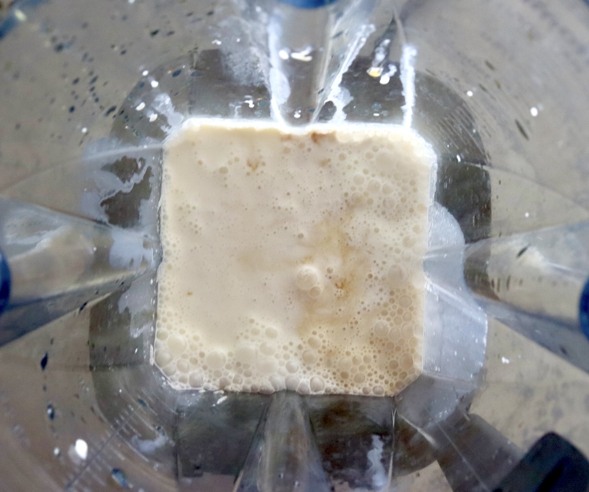 Whipping cream with a splash of vanilla in a blender.