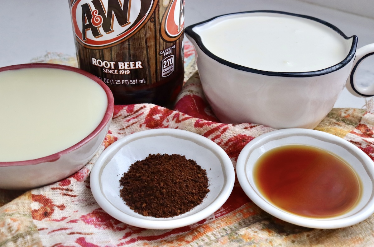 Ingredients for root beer float coffee ice cream including bottle of A&W, bowl of cream, bowl of sweetened condensed milk, vanilla, and ground coffee.