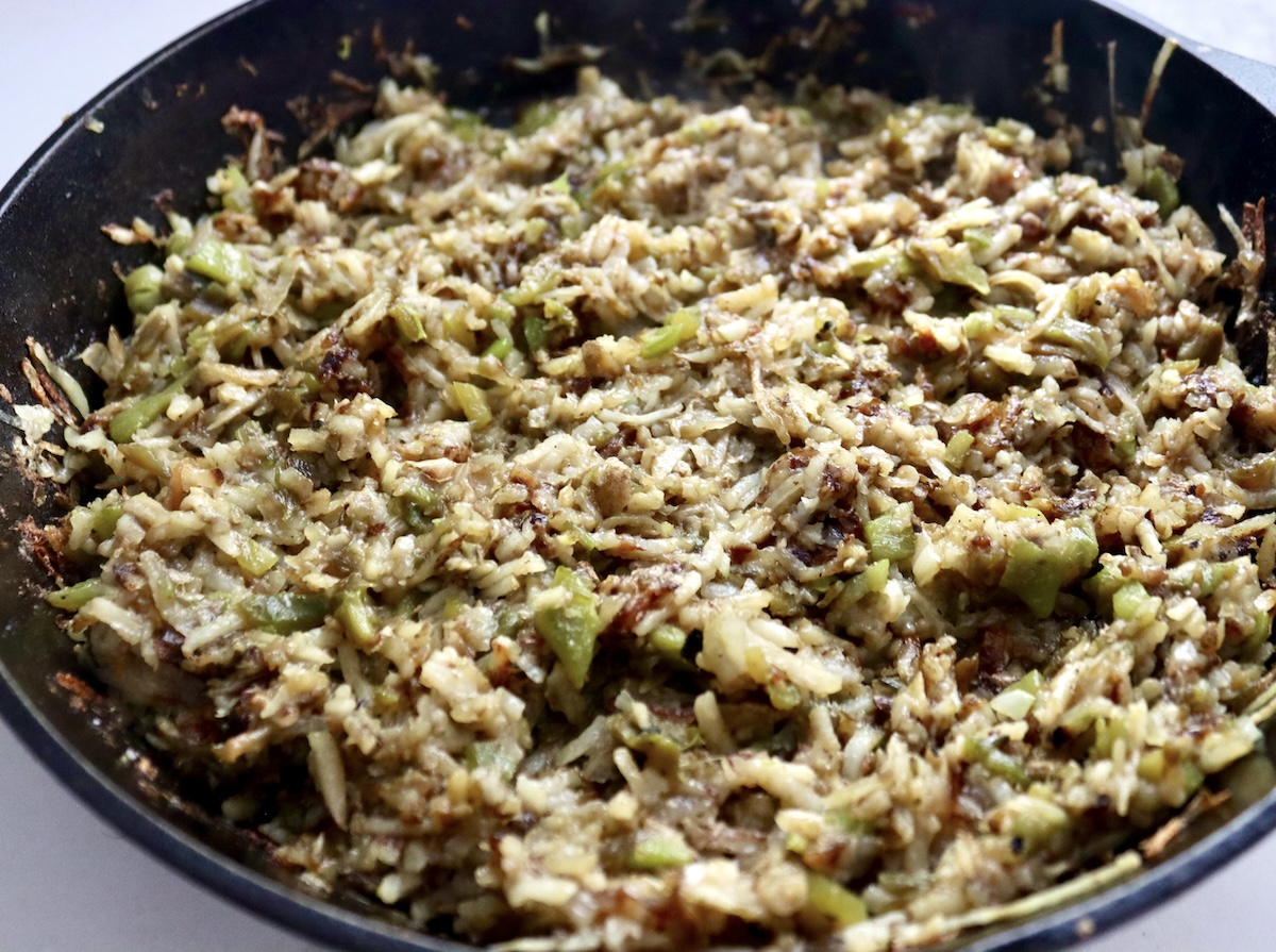 Browned Hatch Browns in a cast iron skillet with onion and Hatch Chiles.