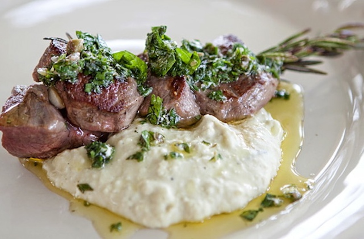 Lamb Skewers with Mint & Feta Salsa and Lima Bean Purée on a white plate.
