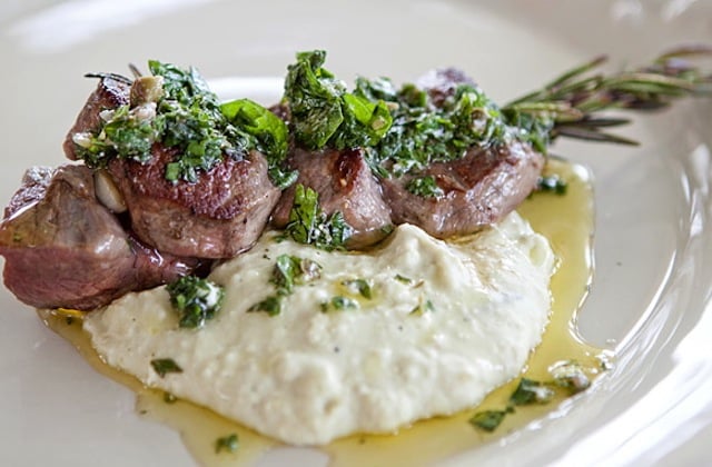 Lamb- Skewers with Mint Feta Salsa and Lima Bean Purée on white plate