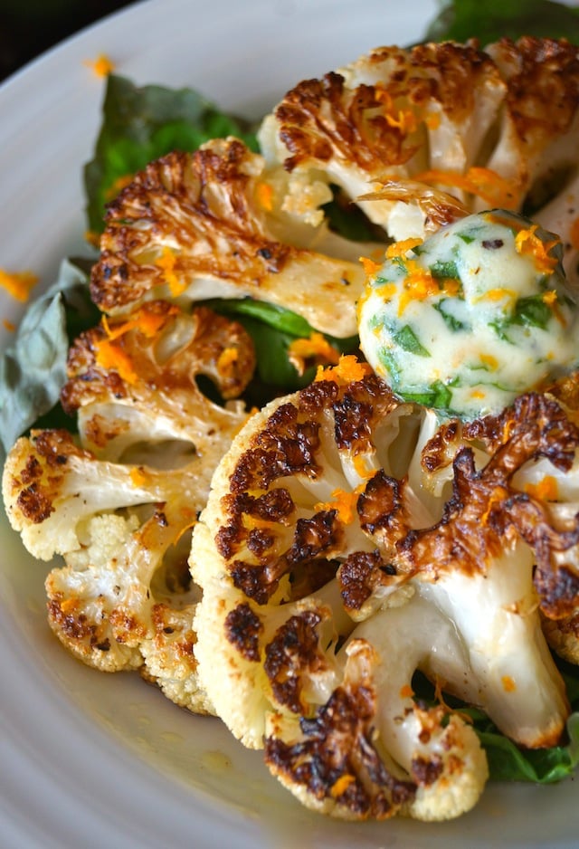 Cauliflower Steaks with Orange-Basil Butter on a white plate