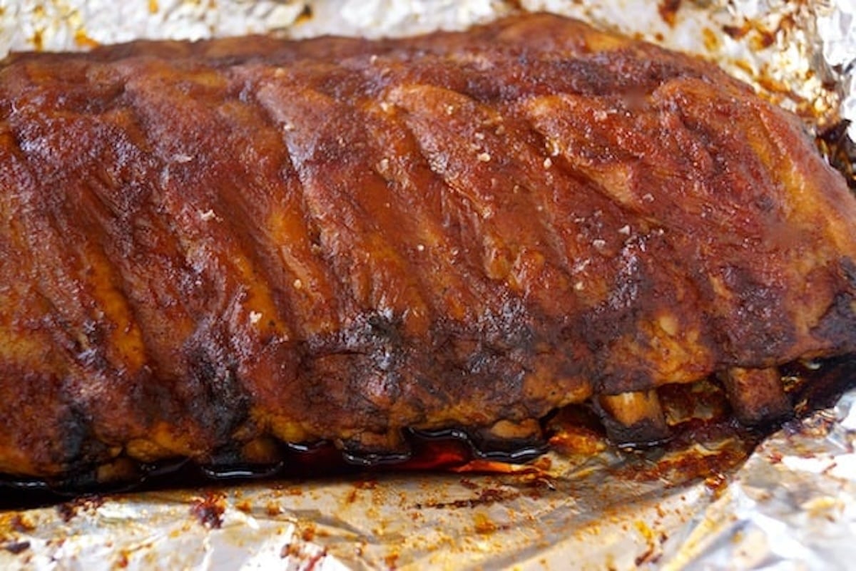 Baked pork ribs with dry rub, on foil.