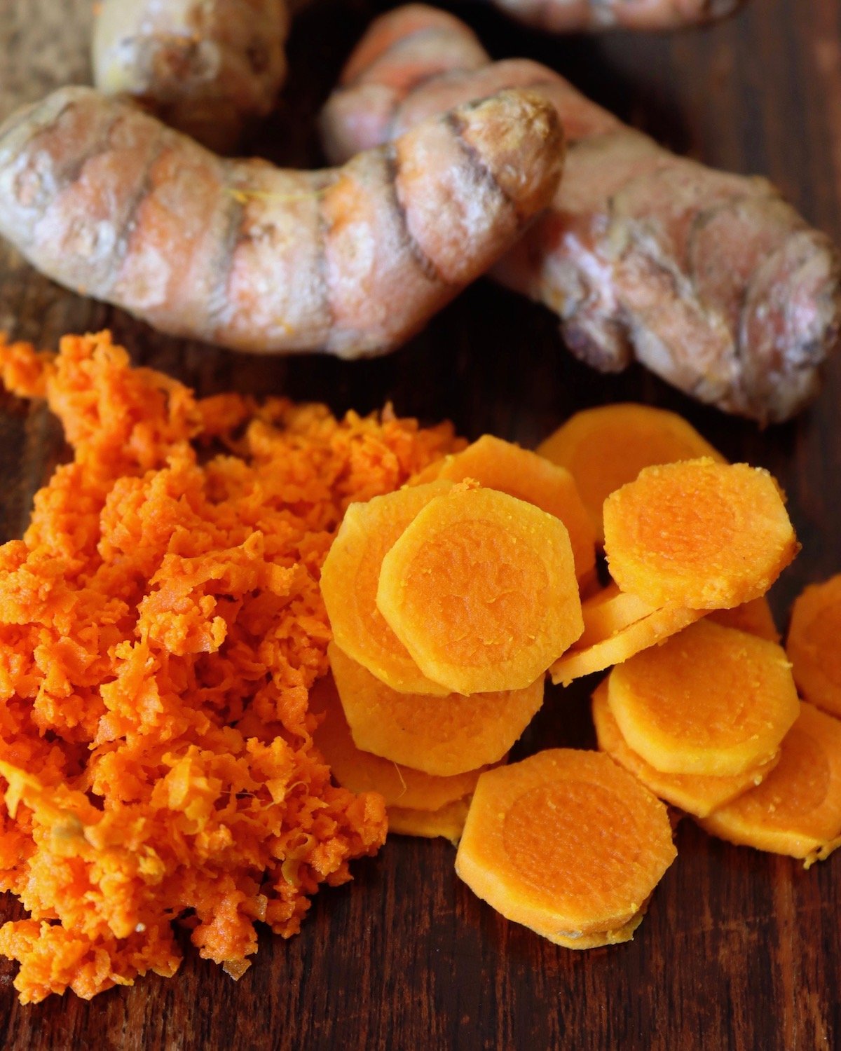 Small pile of grated and sliced turmeric root.