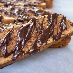 Gluten Free Chocolate Biscotti drizzled with melted chocolate on parchment paper