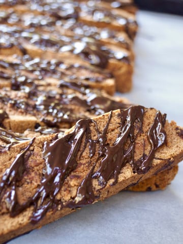 Gluten Free Chocolate Biscotti drizzled with melted chocolate on parchment paper