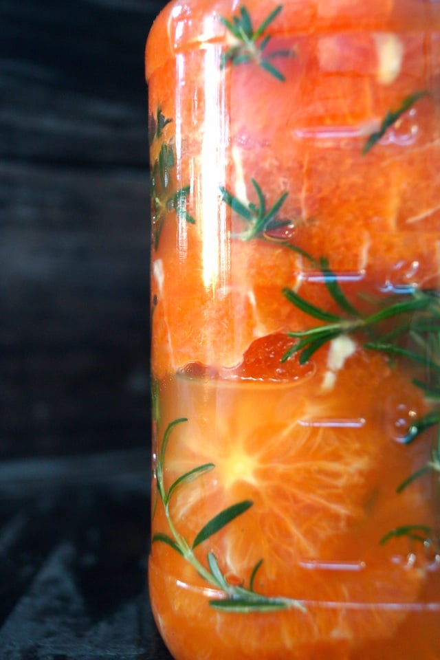 Mainated Oranges with honey and rosemary in a tall jar