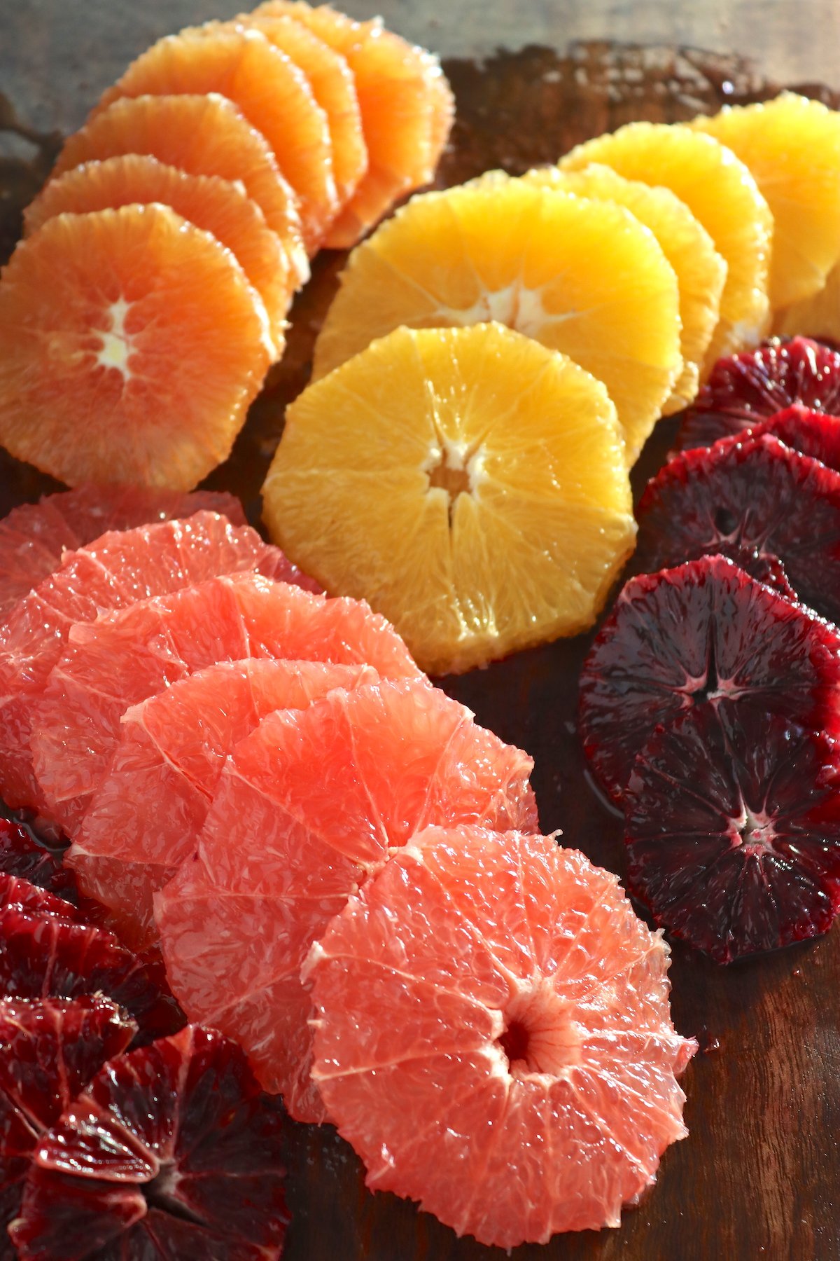 grapefruit, orange and blood orange cut into rounds on cutting board