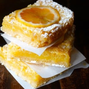 Three stacked Gluten-Free Lemon with Coconut Crust with parchment between them