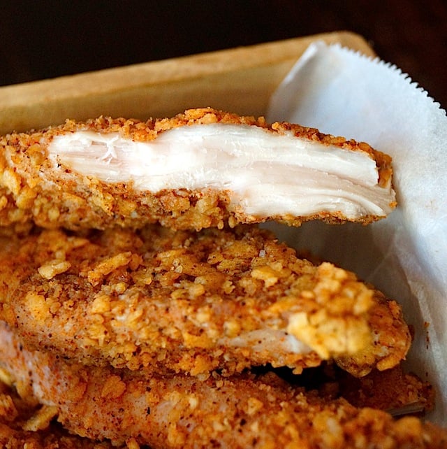 Small pile of Tortilla Chip Crusted Chicken Strips on parchment 