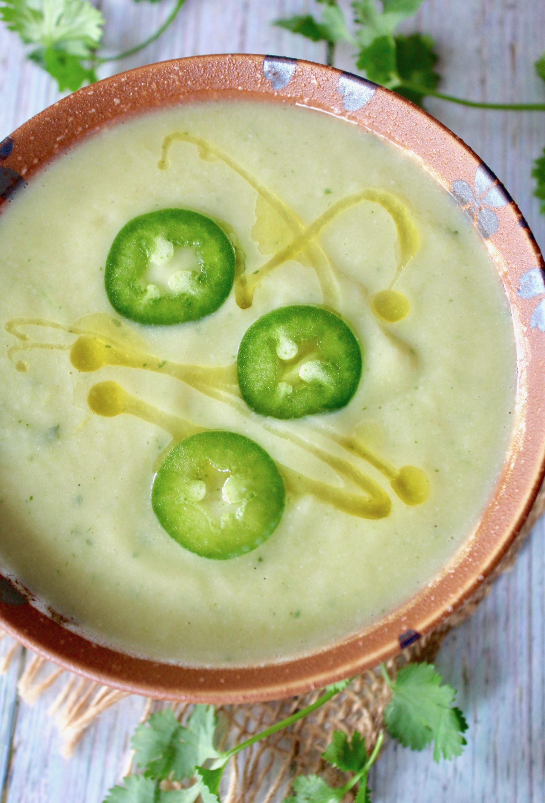 Top view of Cream of Jalapeno Cauliflower soup with 3 slices of jalapeno on top.