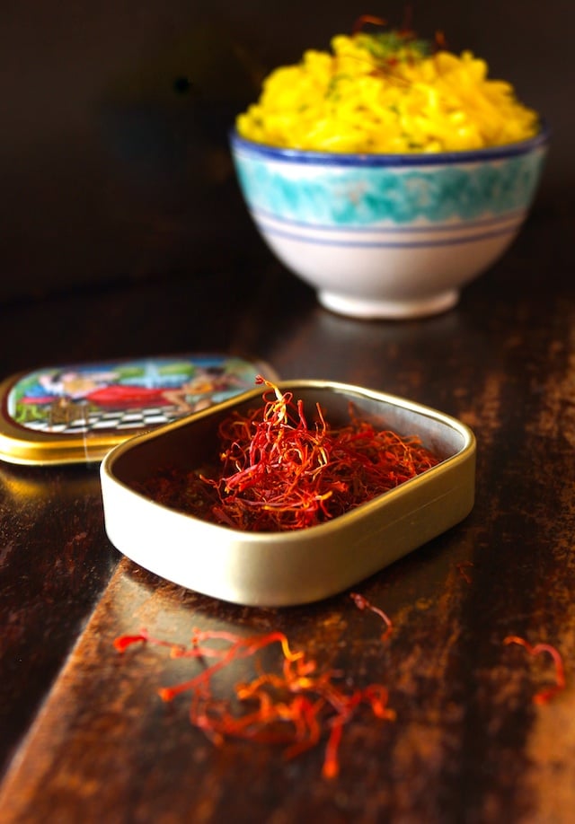 Saffron Basmati Rice Recipe with Fresh Dill in a blue and white, ceramic bowl, with a small case of saffron in the foreground.