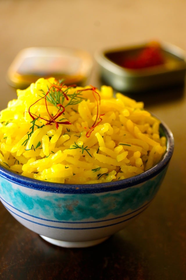 Close up of Saffron Basmati Rice Recipe with Fresh Dill in a pretty blue and white ceramic bowl.