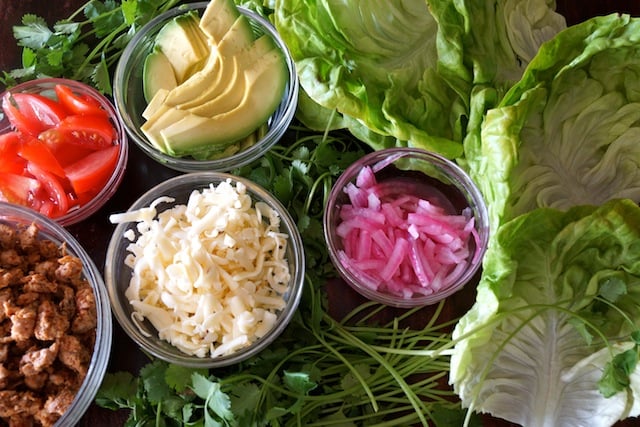 All of the ingreditents in glass bowls for Turkey Lettuce Tacos.