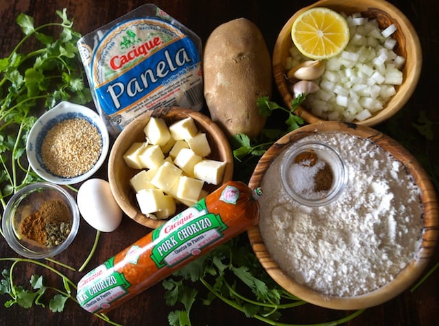 All of the ingredients for Chorizo-Potato Spiced Sesame Hand Pies on a dark board and with lots of fresh cilantro throughtout.