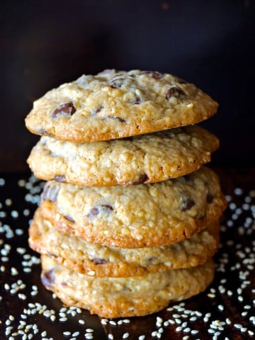 Stack of about 7 Sesame Chocolate Chip Cookies on black background.