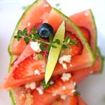 Stack of opposing facing slices of watermelon pizza.