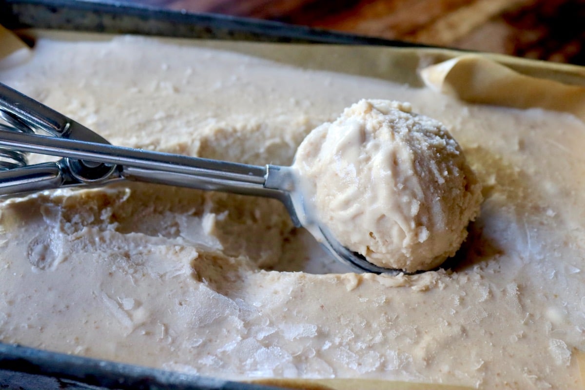 Scoop of guva ice cream on top of ice cream in bread pan.
