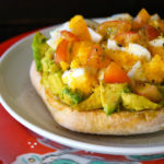 Avocado Toast with Egg and tomatoes on a white and red plate