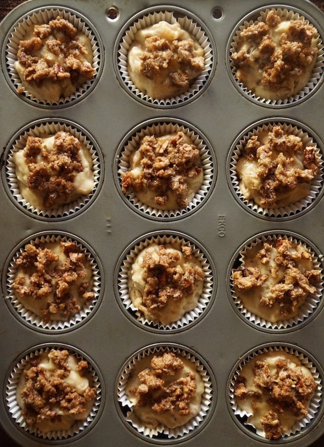 Batter prepped in paper cups in the muffin tins for Spiced Buttermilk Roasted Apple Muffin recipe.