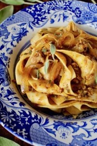 Pumpkin Pasta with Sausage mixed into Pappardelle in a blue and white bowl
