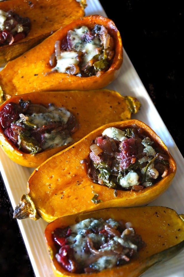 Caramelized Onion-Bacon and Cranberry Honeynut Squash - orange squash are cut in half and filled with cranberries, cheese, and onions