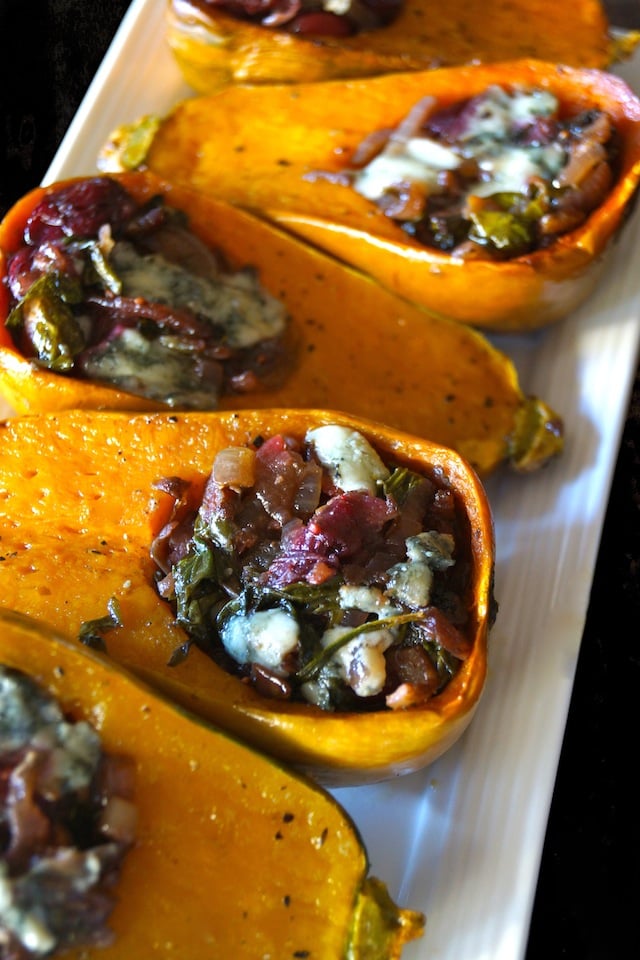 Caramelized Onion-Bacon and Cranberry Honeynut Squash - orange squash are cut in half and filled with cranberries, cheese, and onions