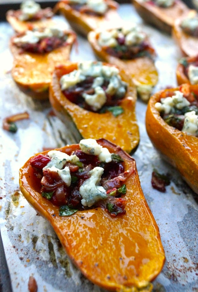 Caramelized Onion-Bacon and Cranberry Honeynut Squash - orange squash are cut in half and filled with cranberries, cheese, and onions