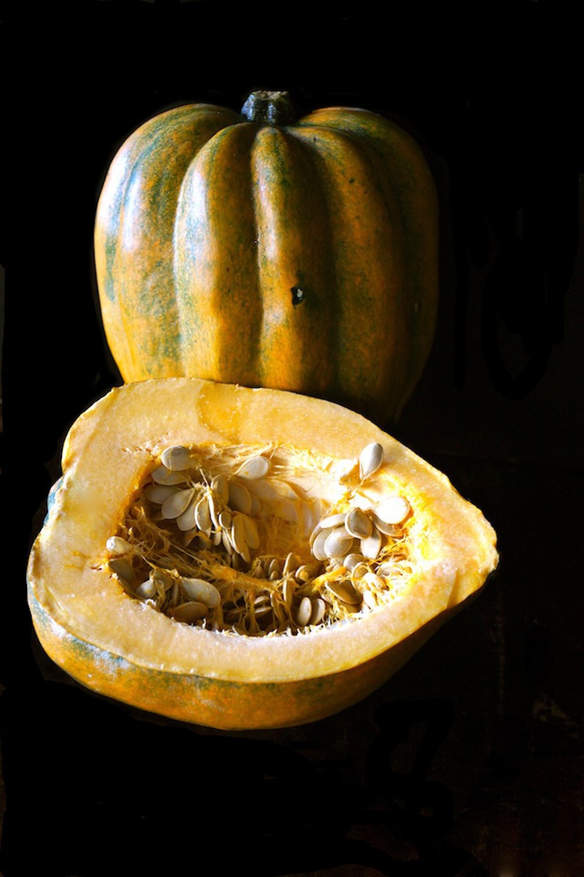 One whole acorn squash cut in half.