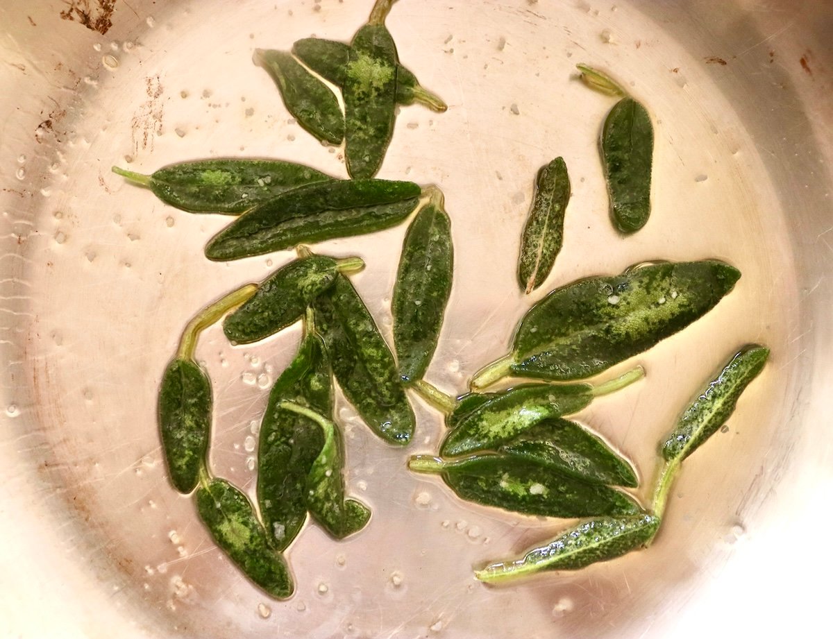 Fresh sage leaves in a small sauté pan.