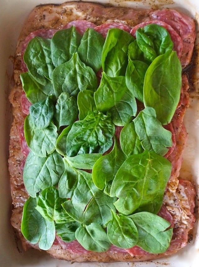 salami and spinach in layers on top of butterflied pork loin