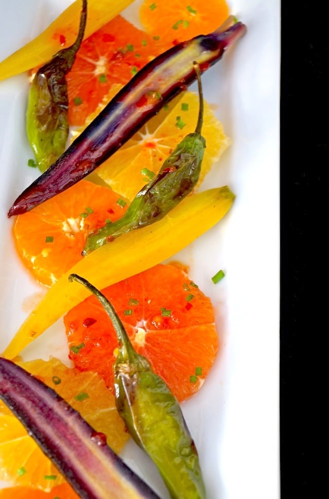 Colorful Citrus Carrot Salad Recipe on white plate with finely chopped chives.