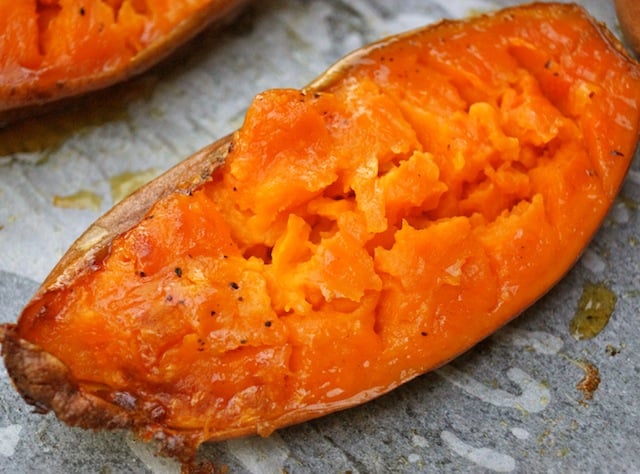 1 half of a baked sweet potato, right out of the oven on parchment.