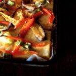 Sheet pan packed with a tofu base and stir-fried colorful veggies on top.