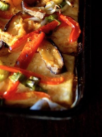 Sheet pan packed with a tofu base and stir-fried colorful veggies on top.