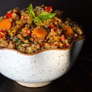 White curvy bowl almost overflowing with vegetable lemon quinoa