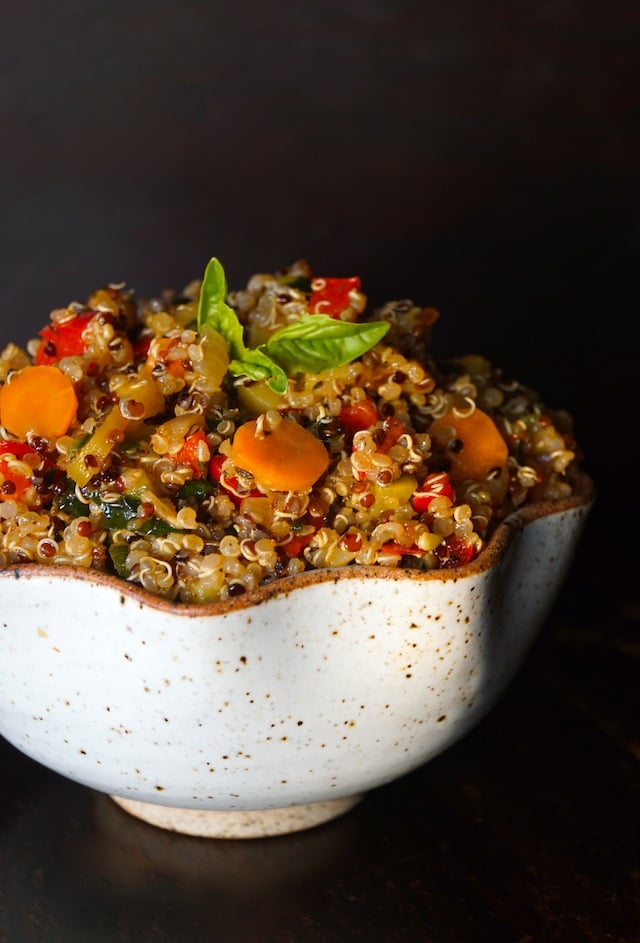 Vegetable Lemon Quinoa Recipe, with bright orange carrot round, red peppers and absil leaves on top 