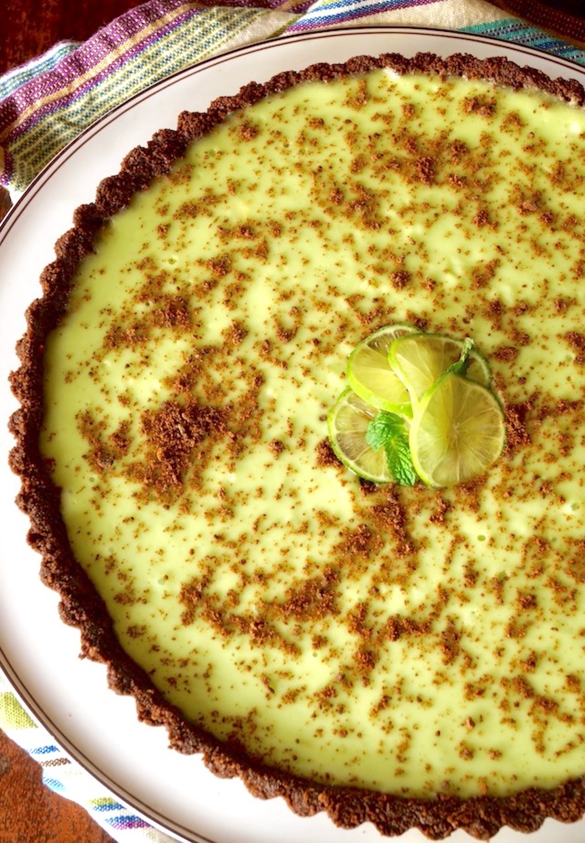 Girl-Scout-Cookie-Recipes-Thin-Mint-Key-Lime-Tart Top view of a Key Lime Thin Mint Chocolate Tart with three lime slices on top.