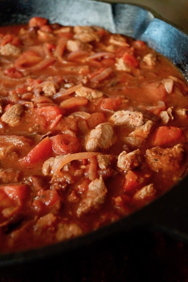 onions, tomatoes and lamb in a cast iron skillet