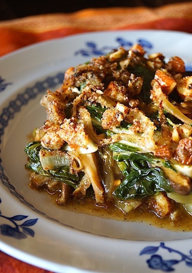 one serving of Bok-Choy-Shitake-Mushroom-Gratin on a white plate with blue flowers ont he rim