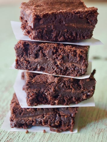 Tall stack of After Eight Brownies with a piece of parchment paper between each one.
