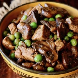 Mushrrom Pork Stew in a deep gold bowl with black rim.