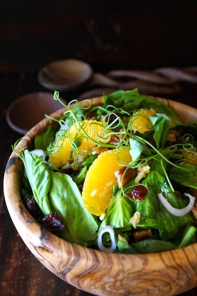 Snow Pea Shoot Salad with Spicy Pecan Dressing in a wooden bowl