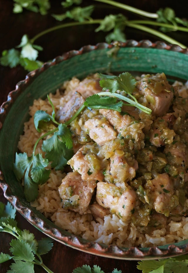 Puerco Con Salsa Verde in a green bowl with fresh cilantro sprigs