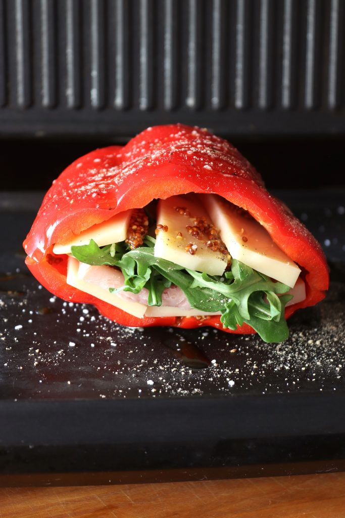 Red bell pepper filled with cheese lettuce and ham on grill