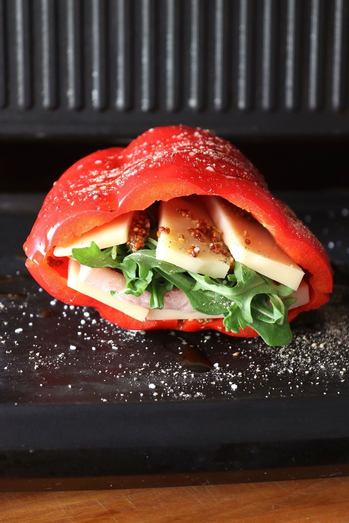 Red bell pepper filled with cheese lettuce and ham on grill