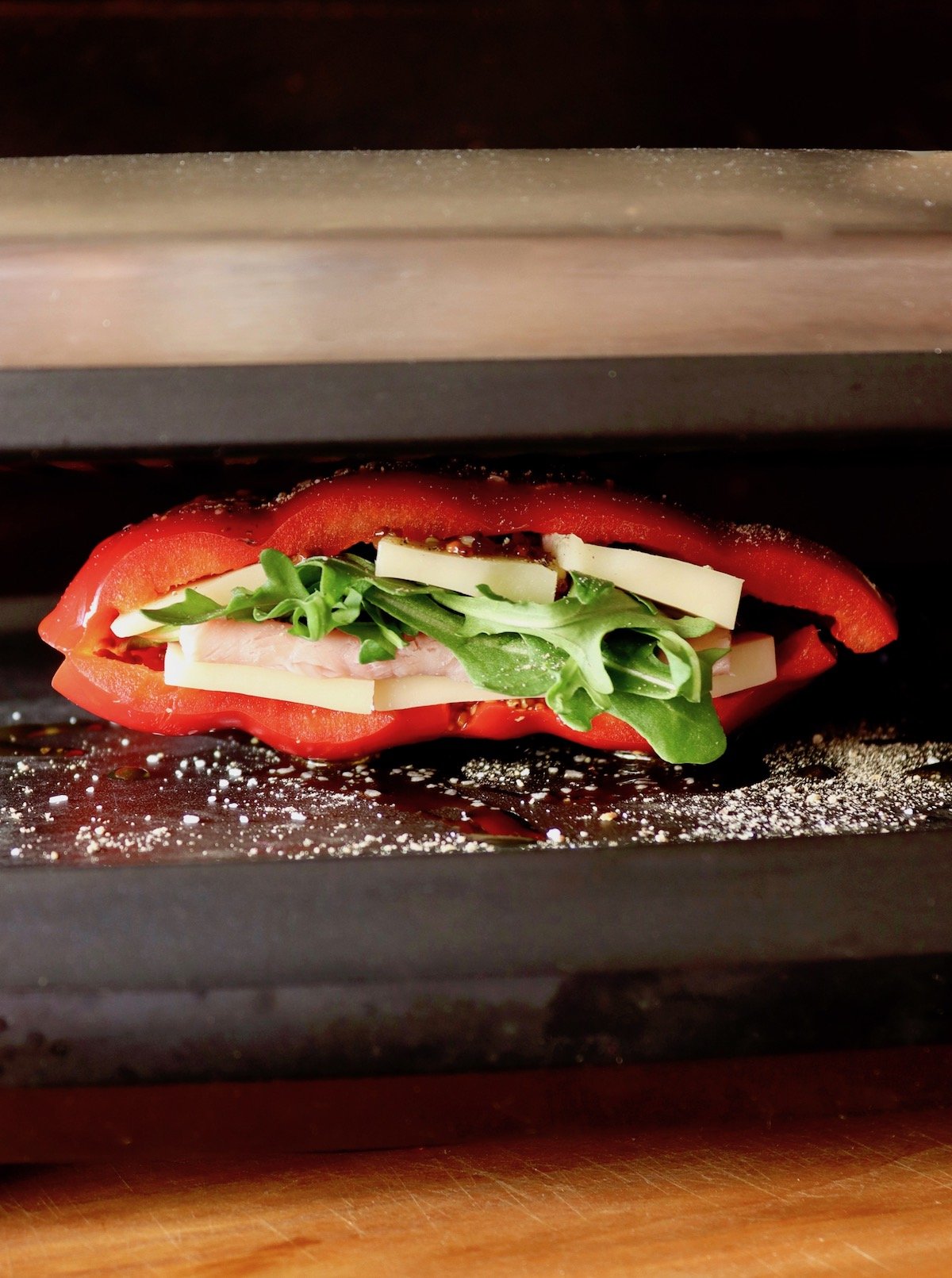 red pepper sandwich in panini press with cheese and lettuce