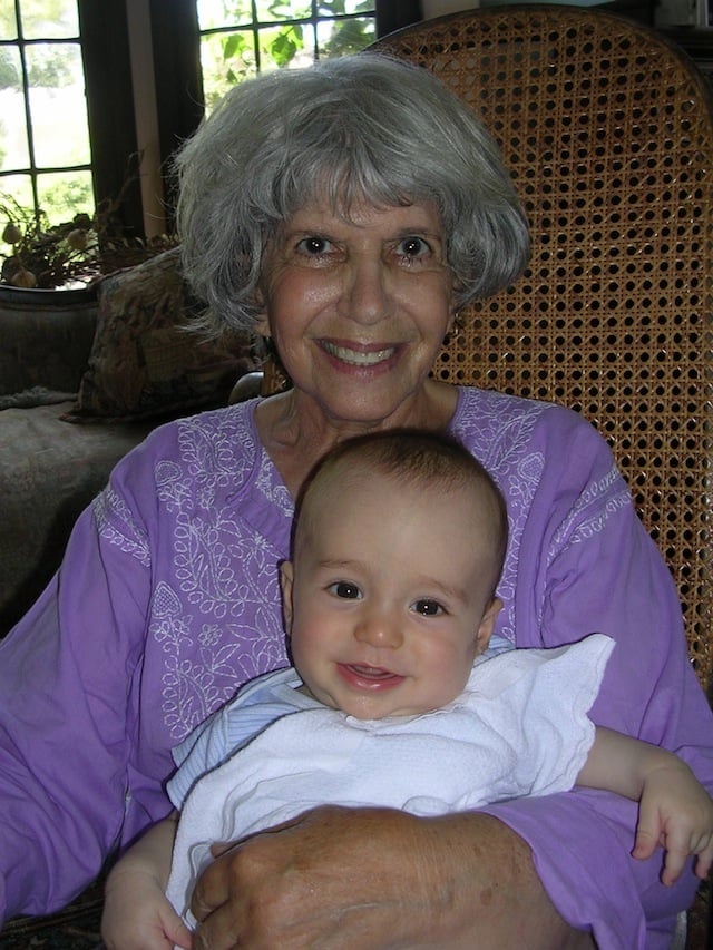 My mom holding my baby boy in rocking chair.